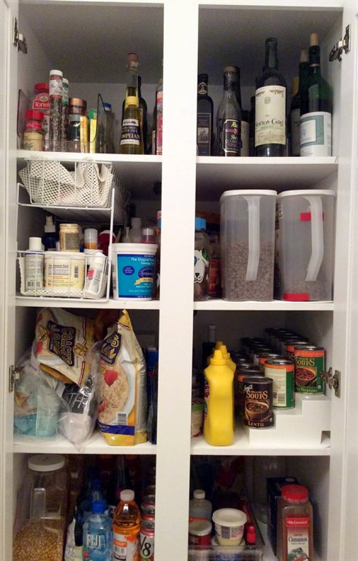 A kitchen pantry cabinet with plastic organizers